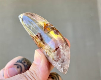 Dôme ovale en cristal de quartz avec inclusions d'hématite rouge foncé, pierre de paume en quartz clair, cristal de quartz poli, Brésil M136