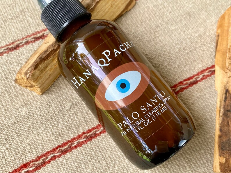 Peut inclure: Une bouteille en verre brun avec un vaporisateur noir et une &eacute;tiquette blanche. L'&eacute;tiquette pr&eacute;sente un &oelig;il brun avec une pupille bleue et le texte "HANA Q PACHA PALO SANTO ALL NATURAL CLEARING SPRAY 4 FL. OZ. (118 ML)"