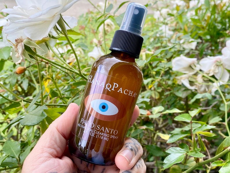 Peut inclure: Une bouteille en verre brun avec un vaporisateur noir et une &eacute;tiquette blanche qui indique "Hanaqpacha Palo Santo All Natural Clearing Spray 4 oz (118 ml)". L'&eacute;tiquette pr&eacute;sente &eacute;galement un &oelig;il bleu avec une pupille blanche et un iris brun.