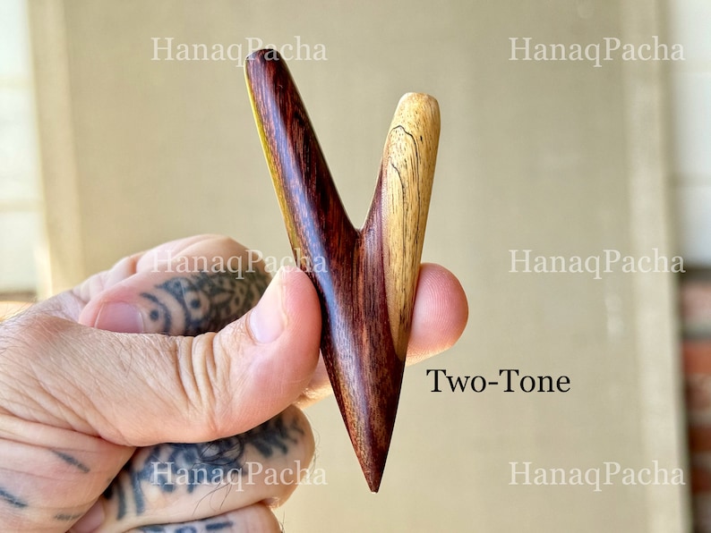 May include: A V-shaped wooden hair accessory featuring a two-tone design with a dark reddish-brown grain on the left side and a lighter tan grain on the right side. The text HanaqPacha and Two-Tone are visible on the image surface.