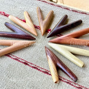 May include: A collection of eight V-shaped wooden massage tools arranged in a circular pattern. Each tool features a smooth, polished finish with distinct wood grain patterns in various shades of light tan, medium brown, and dark espresso brown.