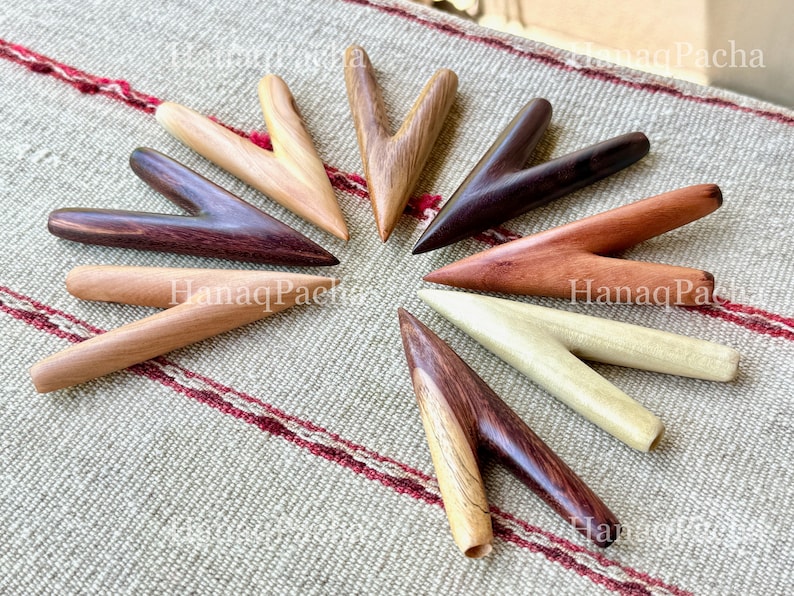May include: A collection of eight V-shaped wooden massage tools arranged in a circular pattern. Each tool features a smooth, polished finish with distinct wood grain patterns in various shades of light tan, medium brown, and dark espresso brown.