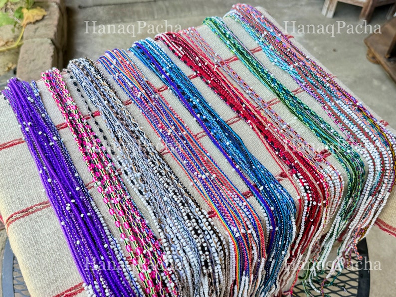 A colorful selection of Watana ties, which can be used as bracelets or to bundle mesas. Available in purple, pink, neutral tones, rainbow, blue, red/orange, green and multicolor pattern.