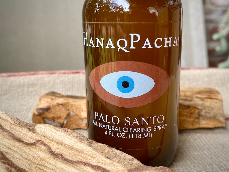 Peut inclure: Une bouteille en verre brun avec une &eacute;tiquette blanche qui indique "HANAPACHA" et "PALO SANTO ALL NATURAL CLEARING SPRAY 4 FL. OZ. (118 ML)". L'&eacute;tiquette pr&eacute;sente &eacute;galement un &oelig;il brun avec un iris bleu et une pupille noire.