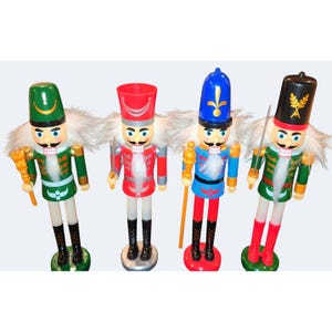 May include: Four nutcracker figures standing in a row, each wearing a tall hat, a uniform jacket, and black or red boots. They feature white faux hair, painted facial details, and hold accessories like staffs or swords in their hands.