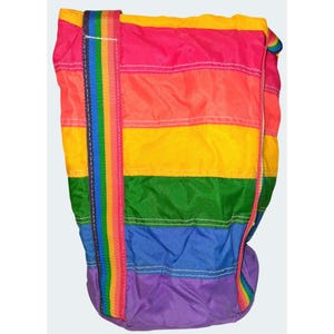 Puede incluir: Un bolso tote a rayas arcoíris con una correa a juego. El bolso presenta rayas horizontales en rosa, naranja, amarillo, verde, azul y morado. La correa tiene un patrón de arcoíris vertical. El bolso está hecho de un material ligero.