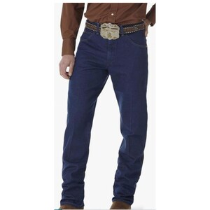 May include: Dark blue denim jeans with a classic straight leg fit. The jeans are worn with a brown leather belt featuring a decorative buckle. The person is also wearing a brown button-down shirt.