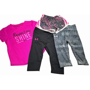 May include: A collection of athletic apparel, including a bright pink t-shirt with the text "Respect my SHINE", black capri leggings, patterned leggings, and pink and black athletic shorts.