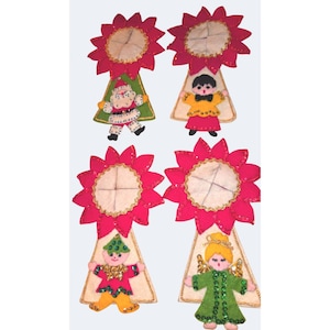 Può includere: Quattro decorazioni in feltro con una parte superiore a forma di stella di Natale rossa e bordo dorato. Ogni decorazione mostra un personaggio diverso: Babbo Natale, una persona in camicia gialla, una in abito rosso e un angelo in abito verde.