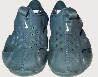 Sandalias Nike negras para niños pequeños con correa ajustable y diseño perforado 4c.