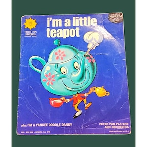 May include: A blue and white teapot with a smiling face and a red and white cup in its hand. The text "I'm a little teapot" is printed in large letters on the record cover. The record is titled "I'm a Little Teapot" and features the Peter Pan Players and Orchestra.