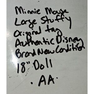 May include: Handwritten text on a white surface. The text reads "Minnie Mouse, Large Stuffy, Original tag, Authentic Disney, Brand New Condition, 18" Doll, AA."