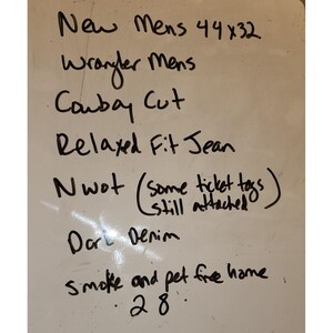 May include: Whiteboard with handwritten text: "New Mens 44x32 Wrangler Mens Cowboy Cut Relaxed Fit Jean Nwot (some ticket tags still attached) Dark Denim smoke and pet free home 28."