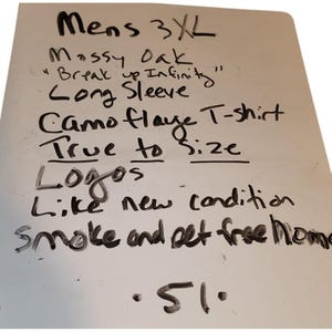 May include: A handwritten list on a white surface. The text includes "Mens 3XL", "Mossy Oak", "Break up Infinity", "Long Sleeve", "Camo flaye T-shirt", "True to size", "Logos", "Like new condition", and "Smoke and pet free home".