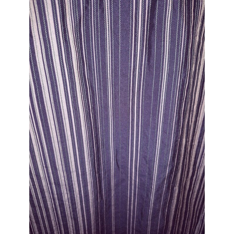 May include: A fabric featuring a vertical striped pattern in shades of dark purple and light lavender. The design consists of alternating wide dark purple bands and thinner, lighter lavender stripes, creating a consistent linear texture throughout.