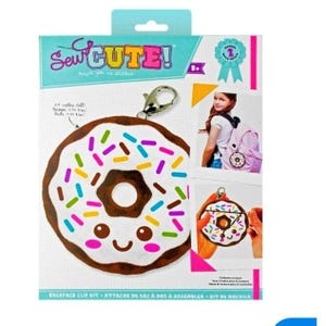 May include: A Sew Cute backpack clip kit featuring a donut design with white frosting and colorful sprinkles. The kit includes a metal clip and is approximately 3 inches tall. The packaging includes the text "Sew Cute!" and "Backpack Clip Kit".