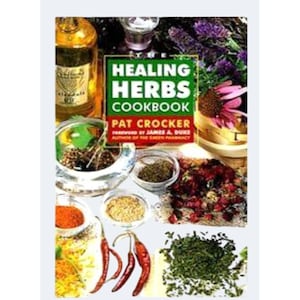 May include: The Healing Herbs Cookbook by Pat Crocker features a green and red cover with text. The image displays various culinary ingredients including a glass bottle of oil, small bowls of spices, dried red chili peppers, and fresh green herbs.