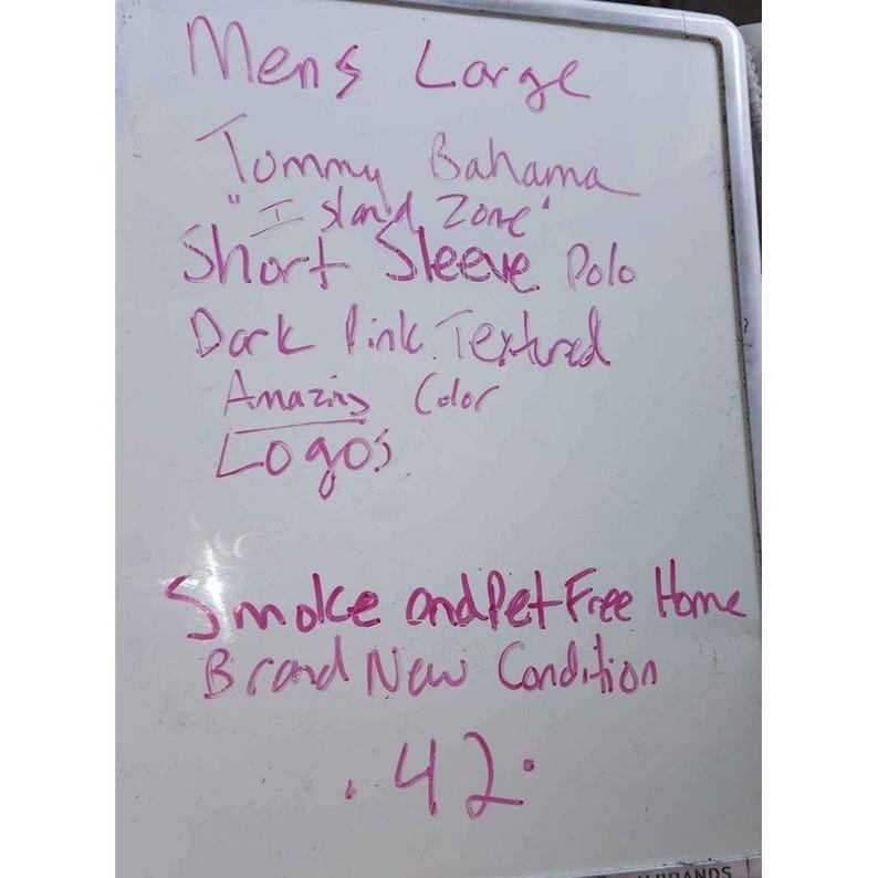Puede incluir: Pizarra con texto escrito a mano en rotulador rosa. El texto describe un polo de manga corta Tommy Bahama "Island Zone", talla grande, en tejido texturizado rosa oscuro. La camisa se describe como de color incre&iacute;ble y con logotipos.