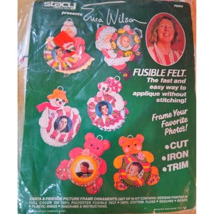 May include: A package of Stacy brand fusible felt ornaments. The kit includes six picture frame ornaments in the shapes of Santa, a snowman, and teddy bears. The ornaments are designed to frame photos and are made of polyester felt with cotton floss, sequins, and beads.