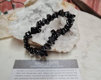 Op de afbeelding: Zwarte Shungite-chip armband. Shungite is een reinigende steen die gifstoffen uit het lichaam verwijdert. Het reinigt en revitaliseert elk chakra en ondersteunt het immuun- en lymfesysteem. Het beschermt tegen negatieve energie en invloeden en werkt de schadelijke effecten van EMF tegen. De trilling kan de energie van een hele kamer reinigen. Het is ook effectief in het verbeteren van mentale helderheid en het zuiveren van iemands emoties, gedachten en intenties. Element: Aarde Chakra: Wortel