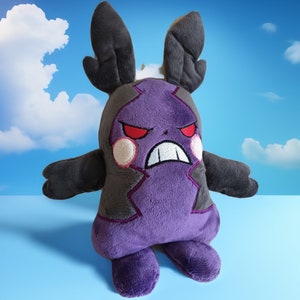 Puede incluir: Juguete de peluche morado y gris con cuernos negros y ojos rojos enojados. El juguete es un personaje de un videojuego popular.