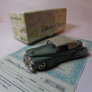 May include: A green and white die-cast model car of a 1940s convertible. The car is on a white card with the text "Collector's Classics Club" printed on it.