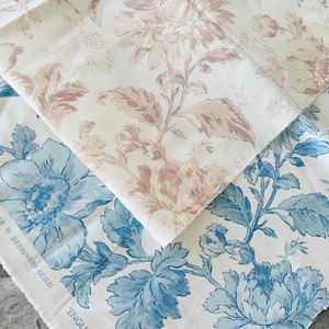 May include: Two fabric swatches with floral patterns. The top swatch features a light brown floral pattern on a white background. The bottom swatch features a blue floral pattern on a white background. The text "English Garden Florals" and "Designed by Designers Guild" is visible on the bottom swatch.