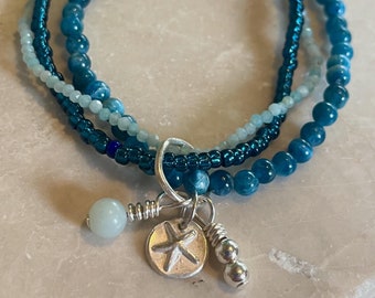 Stacking beaded bracelet with starfish cluster.