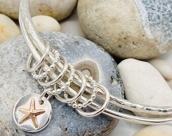 Double silver cluster bangle with starfish disc.