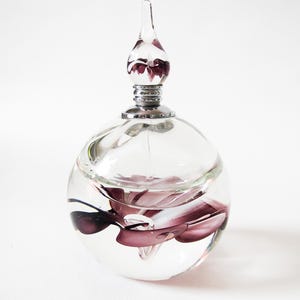 Handmade art glass perfume bottle with a flower inclusion in the base and the dropper. A beautiful addition to the home decor or perfume bottle collection