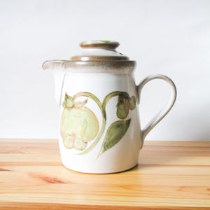May include: A set of three ceramic mugs with a speckled, matte finish. The mugs are in shades of cream, light gray, and dark gray. Each mug has a simple, minimalist design, perfect for coffee or tea.