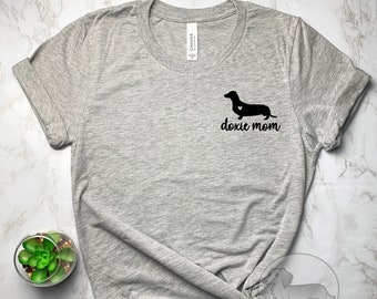 May include: Gray t-shirt with a black dachshund silhouette and the text "doxie mom" printed on the front.
