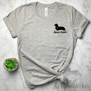 May include: Gray t-shirt with a black dachshund silhouette and the text "doxie mom" printed on the front.