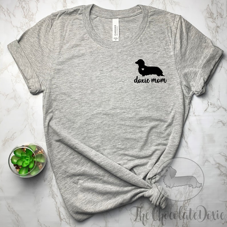 May include: Gray t-shirt with a black dachshund silhouette and the text "doxie mom" printed on the front.