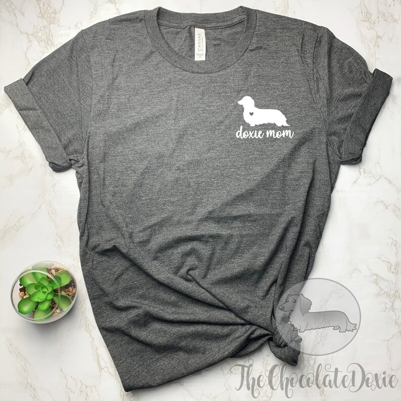 May include: A dark grey t-shirt with a white dachshund silhouette and the text "doxie mom" on the front.