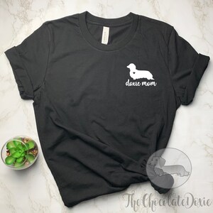 May include: Black t-shirt with a white dachshund silhouette and the text "doxie mom" on the front.