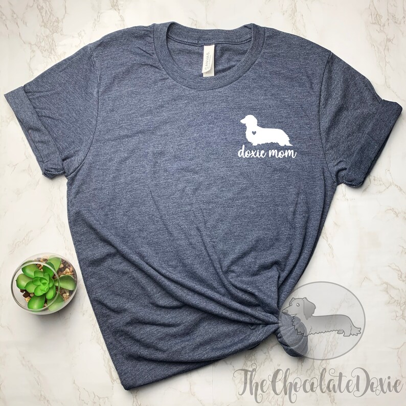 May include: A dark heather grey t-shirt with a white dachshund silhouette and the text "doxie mom" on the front.