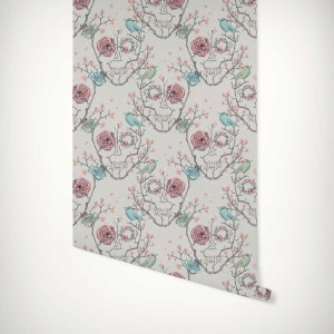 May include: A repeating pattern wallpaper featuring a skull design made of branches and flowers. The skull is surrounded by pink roses, blue birds, and green butterflies. The background is a light grey.