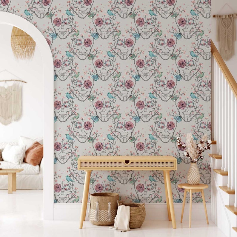 May include: A white wall with a wallpaper pattern of a skull with flowers and birds. The wallpaper is a light grey with a subtle texture. The skull is outlined in black and has pink flowers and blue birds on it. The wallpaper is repeated throughout the wall.