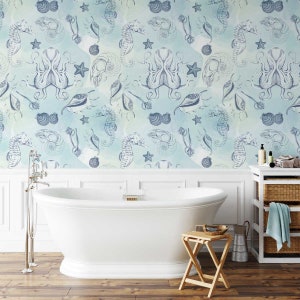 Puede incluir: Una ba&ntilde;era blanca con un papel tapiz de acuarela azul y verde con ilustraciones de caballitos de mar, conchas marinas y pulpos. El papel tapiz tiene un aspecto vintage.