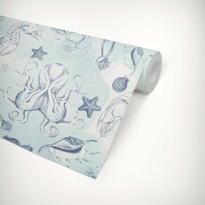 Puede incluir: Un rollo de papel tapiz azul y blanco con un patr&oacute;n repetitivo de criaturas marinas, incluyendo un pulpo, un caballito de mar, una estrella de mar y conchas.
