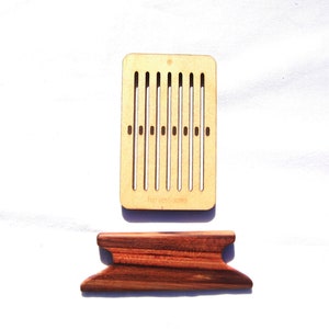 May include: A wooden loom with 10 slots for weaving. The loom is made of light brown wood and has a dark brown base.