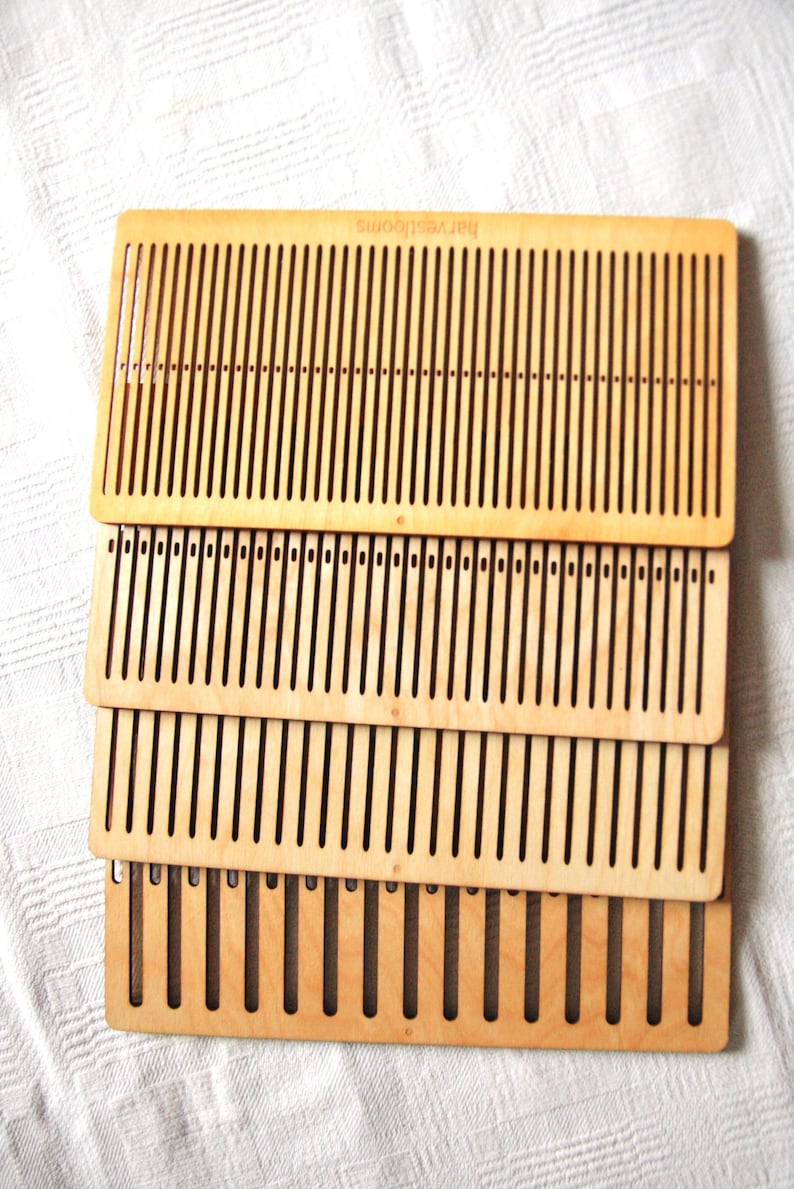 May include: Four wooden weaving looms stacked on top of each other. The looms are made of light brown wood and have a pattern of holes for weaving yarn.