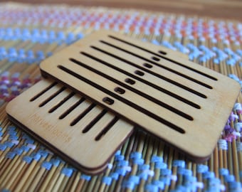 May include: Two wooden weaving looms with slots for yarn. The top loom has a label that reads "harvestlooms".
