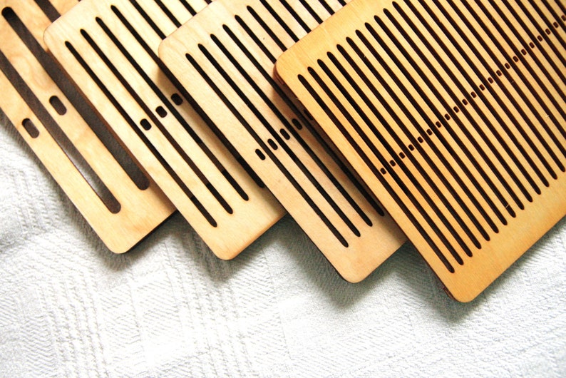 May include: Four wooden weaving looms of different sizes, with a light brown color and black lines. The looms are stacked on top of each other, with the largest loom at the bottom and the smallest loom at the top.