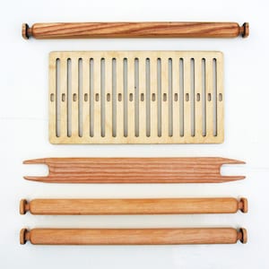 May include: A wooden loom with a wooden shuttle, two wooden rods, and a wooden frame with slots for weaving.