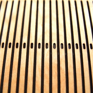 May include: Close-up of a wooden surface with a grid pattern of black lines and evenly spaced holes.