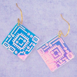 May include: A pair of iridescent earrings with a gold hook and a square-shaped design featuring a circuit board pattern.