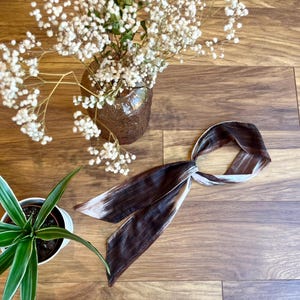 Può includere: Un cartello in legno fatto a mano con la scritta "Welcome" in un carattere giocoso. Il cartello, dipinto di bianco, ha una finitura invecchiata e un piccolo cuore decorativo. Adatto per interni o esterni.