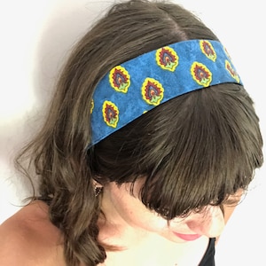 May include: A blue headband with a colorful paisley pattern. The headband is made of fabric and has a stretchy fit.